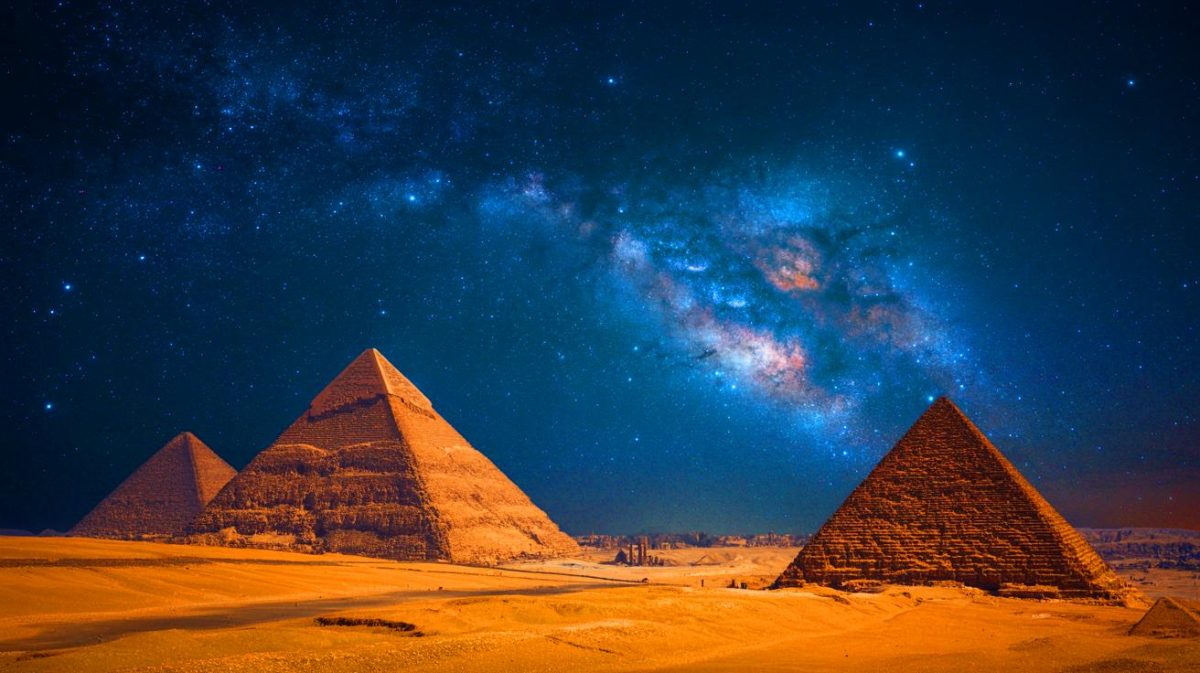 Illustration de la Voie lactée illuminant le ciel nocturne au-dessus des pyramides de Gizeh. Image réalisée par IA.