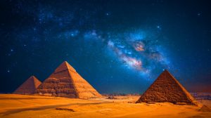 Illustration de la Voie lactée illuminant le ciel nocturne au-dessus des pyramides de Gizeh. Image réalisée par IA.